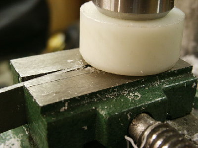 The chisel is passed underneath to finish the face of the piston.