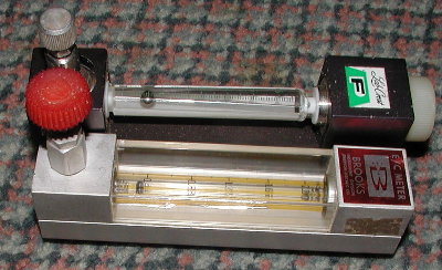 Flowmeters.  The yellow tube is calibrated for 2.0 SCFH of air at standard temprature and pressure.<br /><br />The other one does not specify the gas, but it is marked at 6.5 full scale with a heavier ball and fatter tube.  I'll check it later with air and a pop bottle.