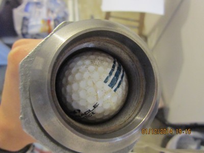 Golf ball just inside of the lip of the pipe. No detent or anything, friction holds it in place just tightly enough to keep it there without applying pressure.