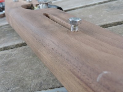 Black walnut (not cheap stuff)! Notice the hairline gap where the wood was jointed. I sawed (by hand) 2 cuts along the length of the wood until I had 3 planks, removed material from the middle plank, then stuck them back together.