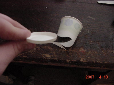 Cut the bottom off of the first cup.Along the line where the bottom is glued to the sides.Next take your hot glue and make a ring on the inside.Push your toilet paper roll(small side) into the cup and let it glue.The cartridge itself is done.