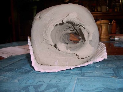 Marble vs. 6 inch clay cube. Suprisingly the entry hole is twice the size of the exit hole. Note the small shock-wave-like ridge that formed above and below the hole (kinda hard to see, appears lighter than the rest).